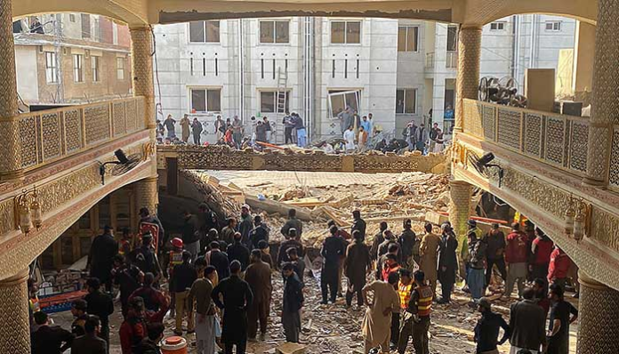 Security officials inspect the blast site inside the police headquarters in Peshawar on January 30, 2023. — AFP