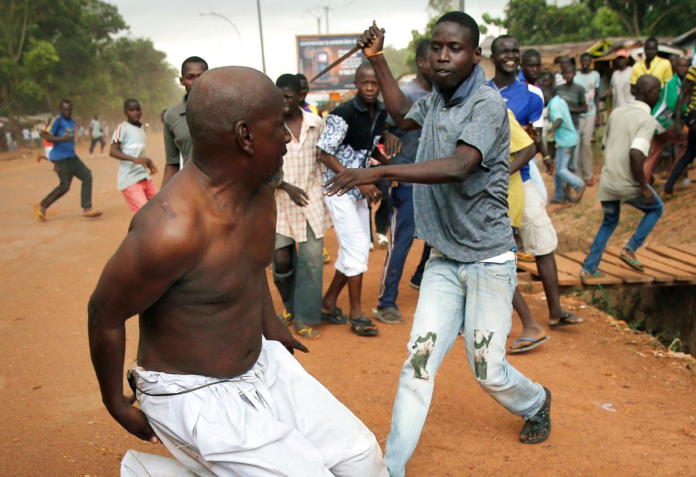 A Christian man chases a suspected Seleka officer in civilian clothes with a knife near the airport in Bangui, Central African Republic, on December 9, 2013. Both Christian and Muslim mobs went on lynching sprees
