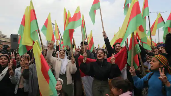 People holding Kurdish flags during a public demonstration for Kurdish rights and independence.