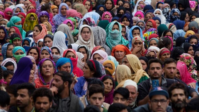 Crowd of Hindu men and women participating in a cultural event or gathering.