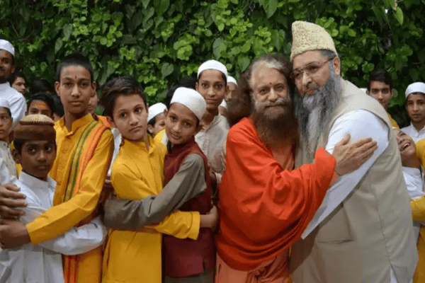Hindu leader Swami Chidanand Muni embracing children during a community event, symbolizing unity and.