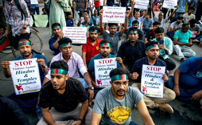Protesters holding signs against Hindu violence in Bangladesh.