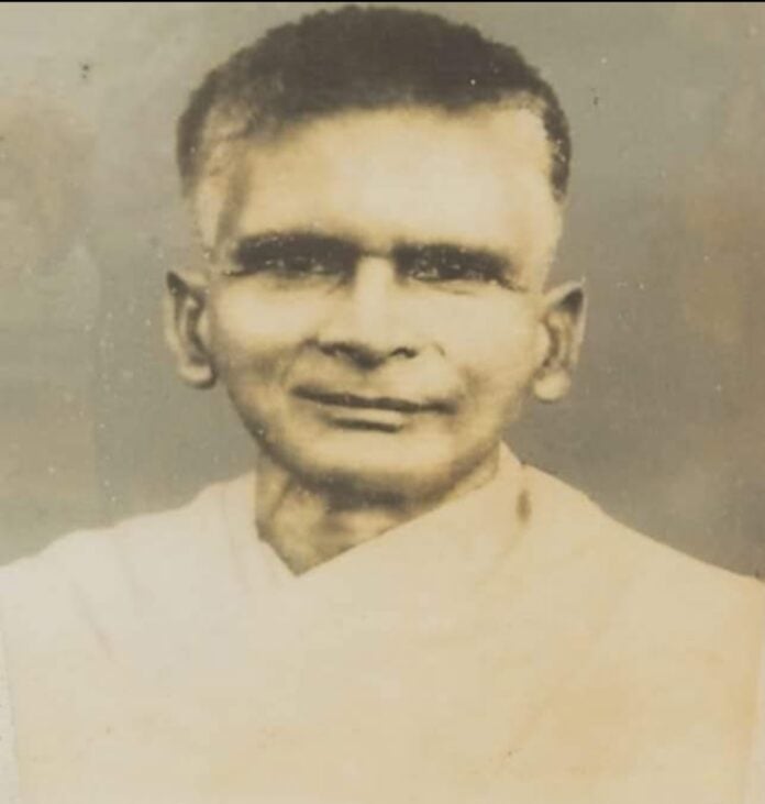 Young man in traditional attire, vintage black and white photo, historical Hindu figure.