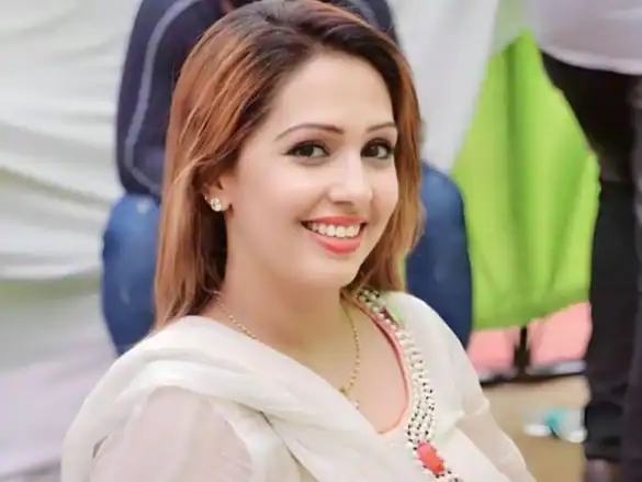 A smiling woman at a public event, highlighting free speech issues related to Khalistan debates.