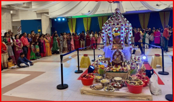 Devotees gather around decorated Navratri altar during festival celebrations.