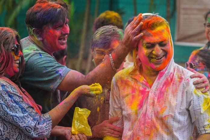People celebrating Holi with colorful powders during the festival of colors.