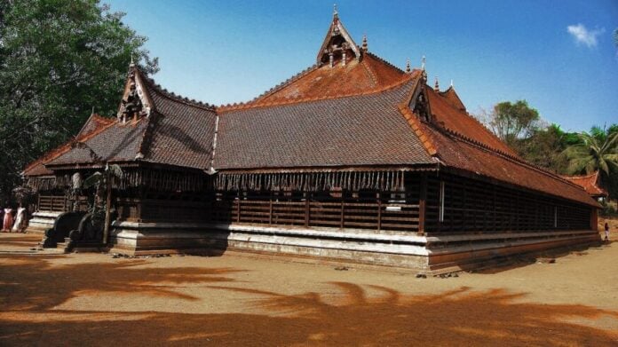 Ancient wooden Hindu temple with intricate design, surrounded by nature.