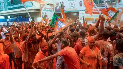 Crowd of supporters at Hindu political rally, waving flags and celebrating.