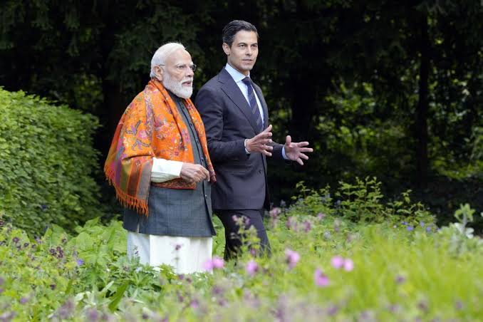 India and France leaders discussing in a lush garden setting, emphasizing diplomatic relations and c.
