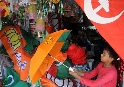 Young girl shopping for political campaign flags and umbrellas at a stall.