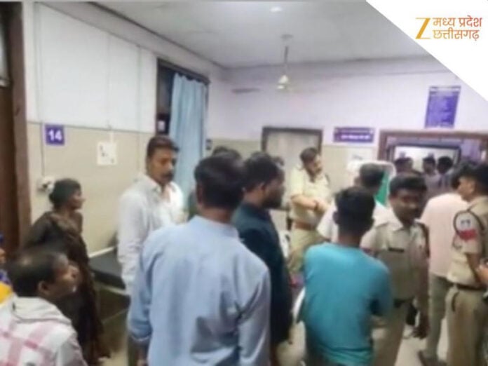 Crowd of people and police officers gathered at hospital reception area in India.