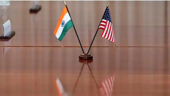 India and US flags on a table symbolizing diplomatic relations.