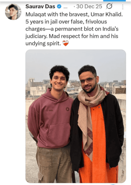 Two men standing on a rooftop in India, smiling, with cityscape background, discussing justice and s.