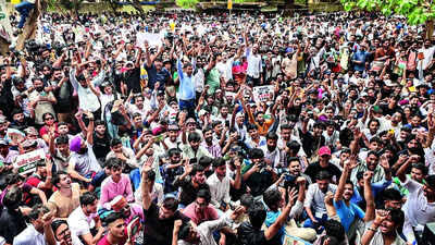 Large crowd of people participating in Hindu festival celebration outdoors.