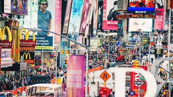 Crowded Times Square with bright billboards and advertisements.