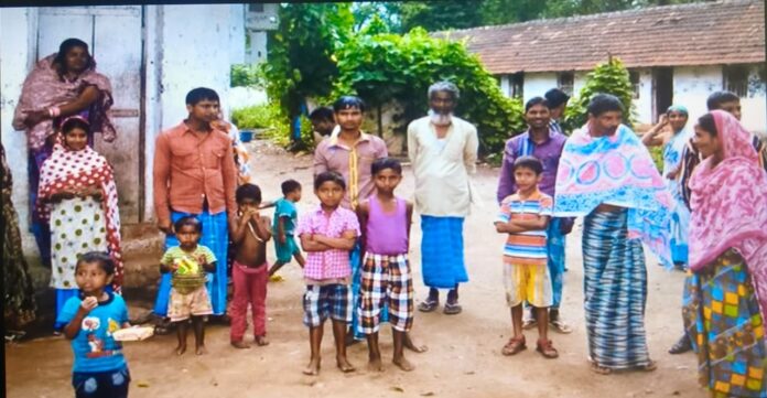 Group of children and adults participating in a community event in rural India.