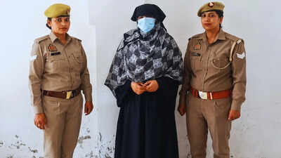 Hindu woman in traditional attire flanked by two police officers in uniform.
