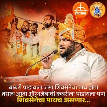 Hindu leader speaking at rally with supporters, wearing traditional turban and saffron scarf.
