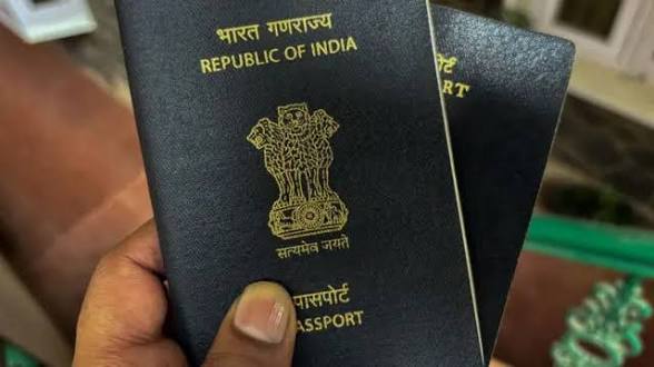 Close-up of Indian passport with national emblem and text.