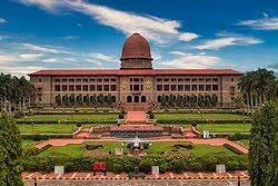 Front view of the Indian National Defence Academy with lush gardens and clear sky.