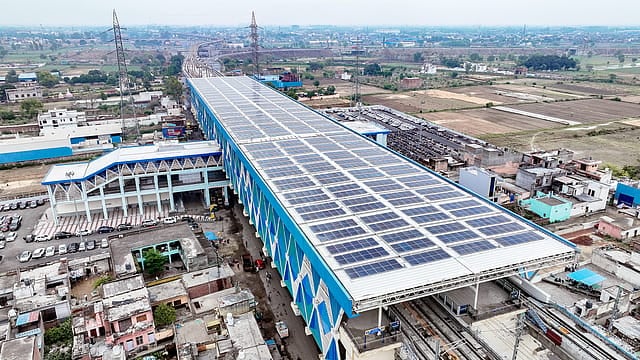 Large rooftop solar panel installation on a modern building in India.