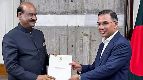 Bangladeshi and Indian officials exchange documents during a formal meeting.